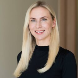 Ritratto di Marta Slaidina, CEO e Direttrice Medica della Clinica EGV, con indosso una maglia nera e lunghi capelli biondi.