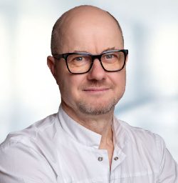 : Fertility doctor Dr. Tomáš Koukal wearing a white medical coat at UNICA Clinic in Brno, specializing in reproductive medicine