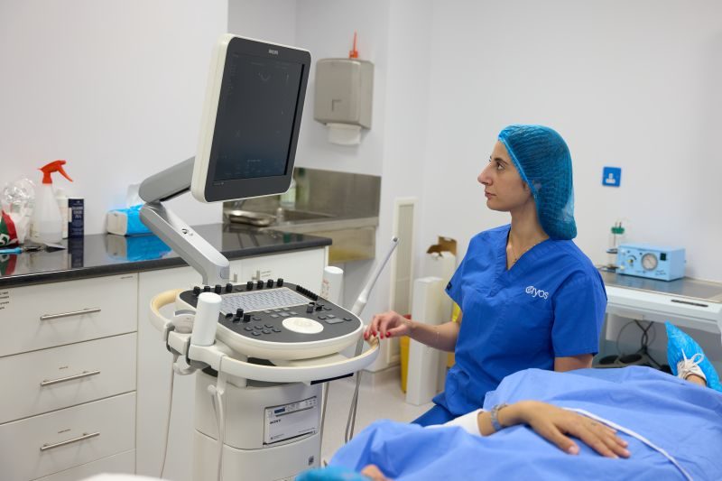 Professionista medico esegue un'ecografia presso la Cryos IVF Clinic Cyprus, mostrando le moderne attrezzature e l'attenzione dedicata durante una procedura di trattamento della fertilità.