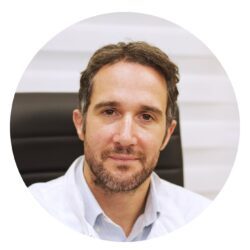 Foto profilo di uno specialista in fecondazione in vitro presso la clinica di medicina riproduttiva Drakopoulos, che mostra un medico in camice bianco seduto su una sedia da ufficio con il volto sfocato per motivi di privacy.